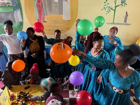Eine Gruppe Menschen die bunte Luftballons hochhalten