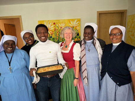 Pfarrer Titound einige Schwestern zusammen mit einer Frau in bayerischer Tracht.