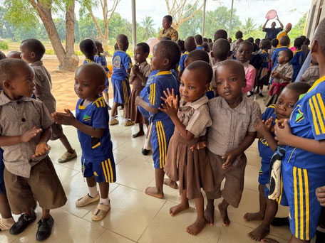 Viele kleine Kinder in braunen und blau gelben Outfits