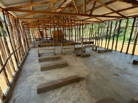 Rohbau eines Gebäudes mit offenen Wänden die nur durch Holzstämme getragen werden