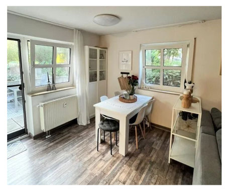 Ein gemütliches Esszimmer innerhalb einer 1,5 Zimmer Wohnung mit weißem Tisch und braunen Laminat in Holzoptik. Diese Wohnung befindet sich in Forchheim und wird durch Kollmer IMMOBILIEN verkauft. Es ist ein Immobilienangebot.