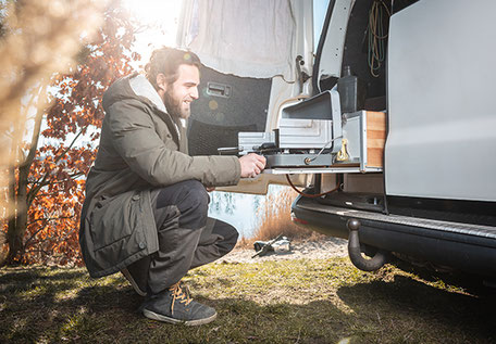 Mann mit Campingkocher am Wohnmobil 2026