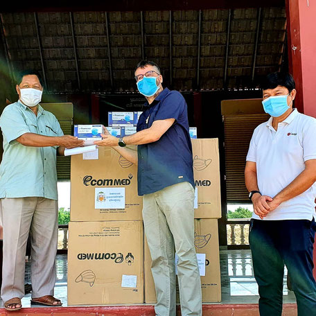 Don de 10.000 masques à la commune d'Areyksat. À gauche, le chef de la commune, et à droite le directeur national de Caritas Cambodge.