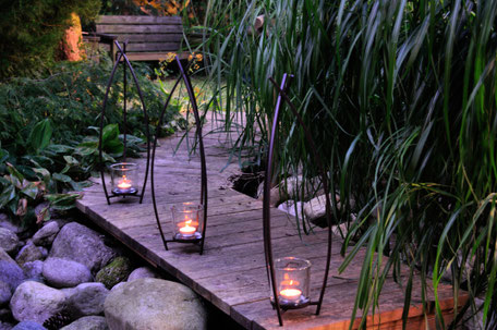 Windlicht Vincent aus Metall mit Glas, sehr schön geschwungene Metallstäbe geben ein ruhiges Licht, welches zu Träumen einlädt und Ihre Terrasse oder Balkon in ein angenehmes warmes Licht taucht.  