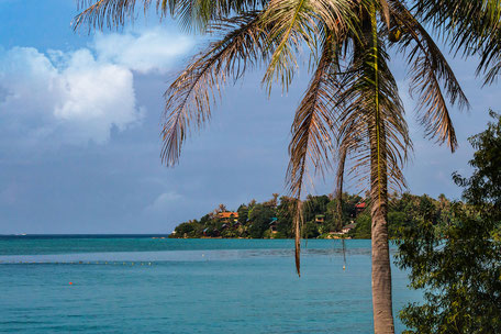 Blick in einer Bucht übers Meer zu Bungalows zwischen Palmen © Jutta M. Jenning mjpics