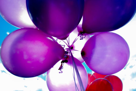 purple ballons under a blue sky