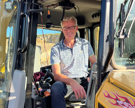 Matthias Schneider auf einem Bulldozer in einer Steinbruchbesichtigung.