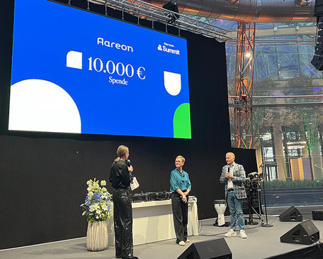 Dr. Ernesto Marinelli, Chief People Officer Aareon, überreichte die Spende für die DESWOS an Petra Eggert-Höfel, Vorstandsvorsitzende DESWOS