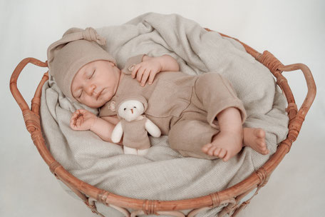 Neugeborenes Baby liegt in einem Korb – liebevolles und natürliches Babyshooting