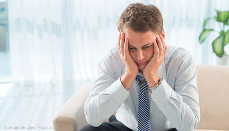 Mann, der die Hände in den Kopf stützt