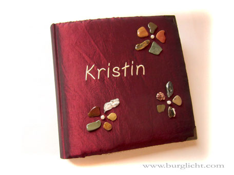 Fotoalbum, Hardcover-Bucheinband gepolstert, Stoff Taft dunkelrot, Wunsch-Accessoires: Steinblumen lackiert und Kunststoffperlen; Name gestickt, Metall-Buchecken, 30cm x 30cm, 50 Blatt naturweiß.