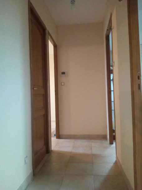 Photo montrant la pose d’une toile de verre sur un mur fissuré à Puimisson par Peinture Audiffren, artisan peintre professionnel, renforçant le support et préparant la surface pour une peinture durable et esthétique.