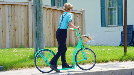 Amish Junge mit Rad-Roller