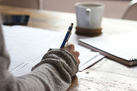 Ein Arm und eine Hand bei einer Schreibtätigkeit im Büro, so wie bei der gesuchten Assistenz bei der Finanzberatung von Eloquent Invest, Melanie Schneider