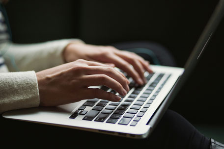 Hände an der Laptoptastatur, so wie bei der gesuchten Assistenz bei der Finanzberatung von Eloquent Invest, Melanie Schneider