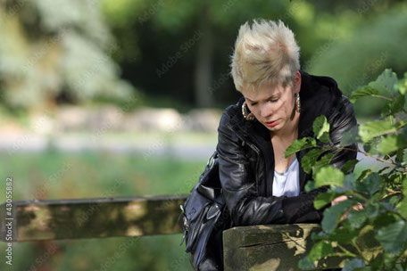 Eine junge Frau traurig bei der Grabpflege