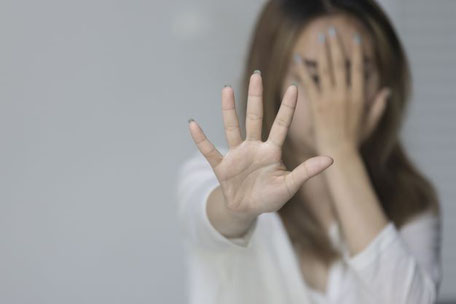 Frau schlägt eine Hand vors Gesicht und wehrt mit der anderen Hand ab als Motiv für Vortrag von Georgia Middel zu Ängsten und Zwängen