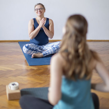 Doris Götz und Yogaschülerin im Schneidersitz