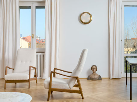 Nel living con vista sui tetti della città, due poltrone Modello 829 di Arnestad Bruk (Cassina) e mezzo busto ligneo del ’500 ispirato all’opera di Francesco Laurana.