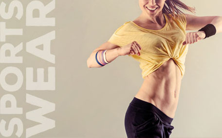 Frau in Sportkleidung hebt ihr gelbes Shirt an, daneben steht der Schriftzug „SPORTS WEAR“.