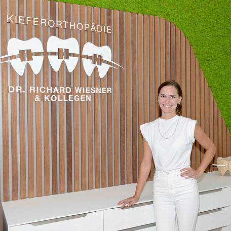 Fachärztin Dr. Anna Nagel steht an der Rezeption der Praxis für Kieferorthopädie München Freimann.