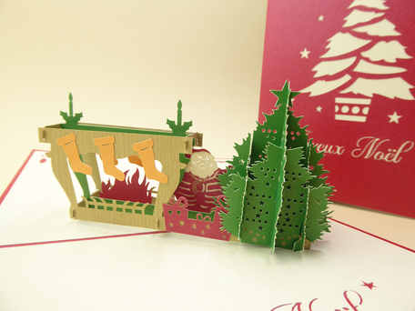 Carte de voeux en pop-up avec un père noël près de la cheminée Joyeux Noël