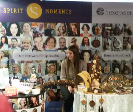 Messestand bei den Naturheiltagen vom Netzwerk für Spiritualität mit Bildern der Personen des Netzwerkes