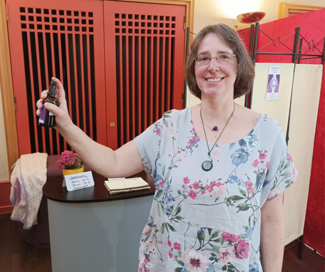 Geistheilerin Ina Paulus hält eine Spray in der Hand am Messestand bei den Naturheiltagen