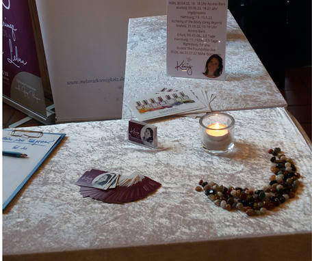 Messestand mit Visitenkarten, Steinen auf einem Tisch mit einer weißen Decke bei den Naturheiltagen