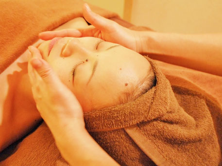 リラックスフェイシャルによるアロマトリートメントで顔の施術をしている様子