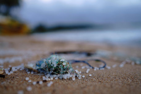 Kunststoff Pellets angespült am Saum eines Sandstrandes. Stellvertretend für die Motivation der Mikroplastik Beschränkung des Anhangs XVII der REACH Verordnung sind Synthetische Polymermikropartikel (SPM) in Form von Kunststoff Pellets gezeigt.