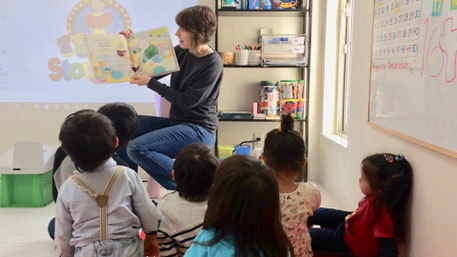 函館市の英語幼稚園＆子供向け英会話教室で絵本の読み聞かせをしているネイティブ講師と子どもたち