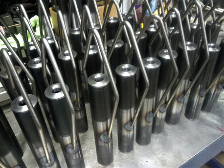 A row of tubes of the glove dryer before further processing on a steel table