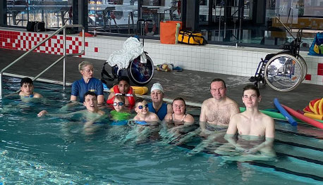 Schwimmgruppe mit Betreuern im Bad