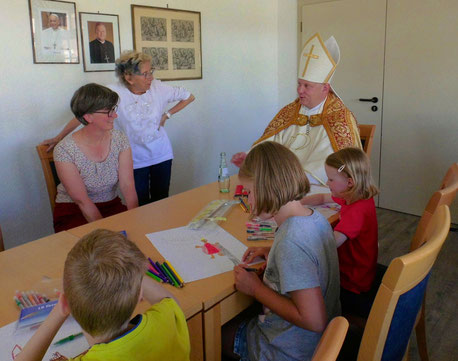 Zusammen an einem Tisch sitzen der Nikolaus, drei Kinder, die am Malwettbewerb teilnehmen und Insel-Seelsorgerin Susanne Wübker