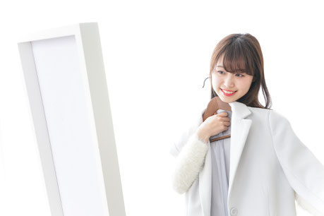 鏡を見ながらジャケットを胸にあてている様子
