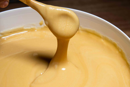 Photo d'une cuillère en bois avec du Miel de Thym de Nouvelle-Zélande qui est dans un seau de 10 kg