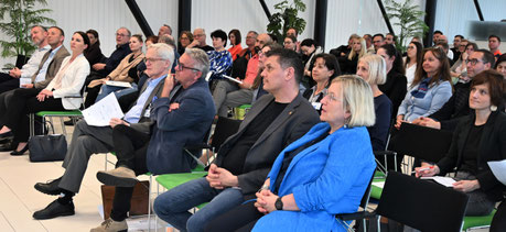 Zuhörer:innen mit Blick zur Bühne, interessiert und aktiv