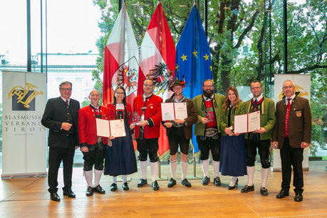 Jugendorchesterleiter Sebastian Pretis (Bildmitte) mit LH Günther Platter (links) und Blasmusikverbandsobmann Elmar Juen (rechts)