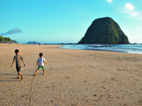 Spelen op het uitgestrekte strand van Red Island beach op oost Java