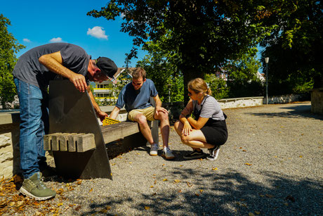 Die Personen auf dem Bild lösen gerade ein Rätsel und geniessen Ihren Teamevent. Das Bild wurde hinter der Altstadt Sursee aufgenommen.