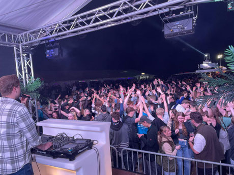 Feiernde Gäste auf der Tanzfläche bei einer Party mit DJ Brave. Tanzende Menschen in stimmungsvoller Beleuchtung.