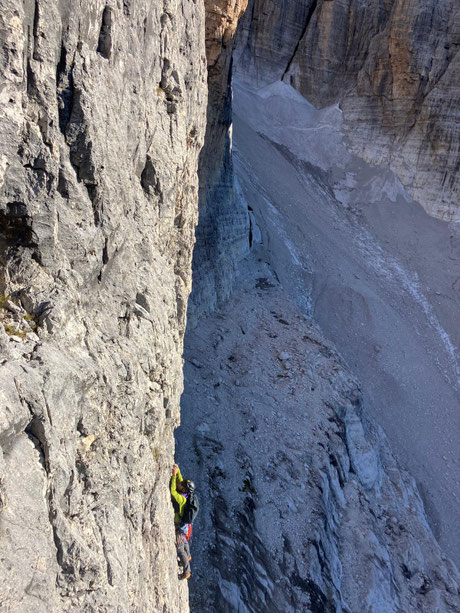 Kletterer mitten in der Felswand auf dem Weg zum Berggipfel