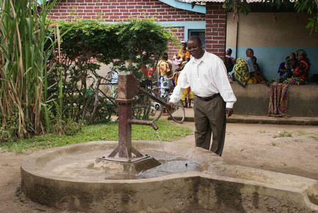 Das erste Projekt in Mofu: Pfarrer Wenseslaus Kayera ist stolz auf den neuen Brunnen. Dank des Brunnens erhalten die Menschen Zugang zu sauberem Trinkwasser.