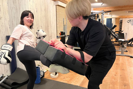 キックボクシングでラウンドハウスキックを蹴る女性