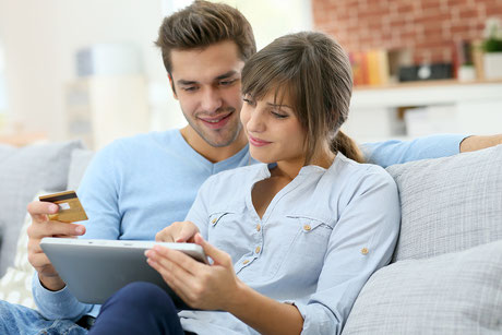 Junge Ehepaare, die im Internet einkaufen mit Tablette