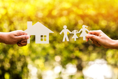 Das Spargeld für Immobilieneigentümer in der Zukunft Konzept, ein Mann und Frau Hand halten eine Familie und Haus mit Modell im öffentlichen Park.