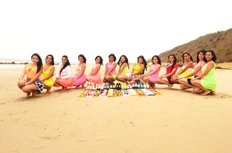En cuclillas sobre la playa de mar, las candidatas a "Señorita NOvato 2014-2015" de la Uleam. Manta, Ecuador.