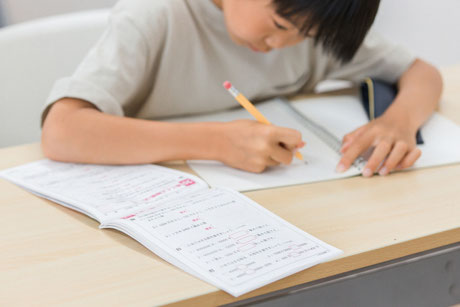 猫背になって勉強する子供