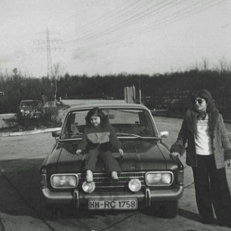 Ebru Tongar als kleines Mädchen auf einem 70er Jahre Ford. Daneben ihre Mutter. 